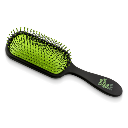 Pro detangling hairbrush in black with green pad laying flat